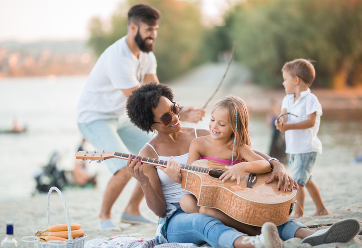Mom and daughter play guitar, and dad and son play fencing